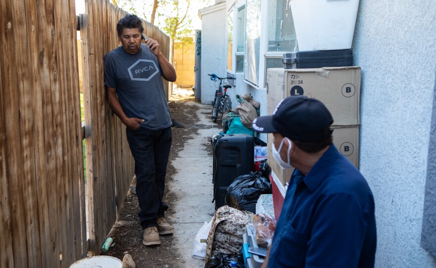 Antonio Cuevas, left, and Alejandro Cazares moved belongings from the Calexico encampment to the outside of a neighbor's apartment, April 7, 2020. Both have agreed to stay in a Calexico shelter for the night if there are beds available for them.