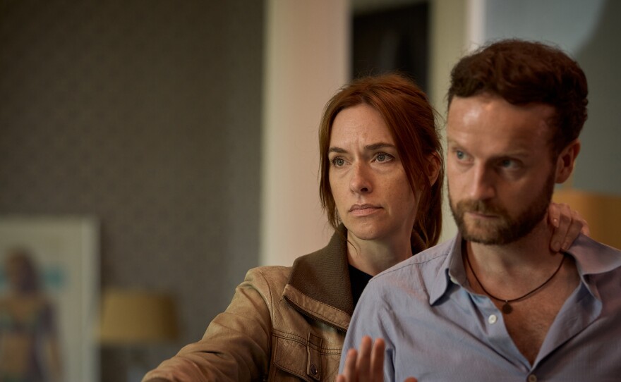 Shown L-R: Kalie (Kim Riedle), Xavi Franken (Andrew Gower). The investigation continues after a whistleblower is murdered. The team are offered the chance to work with the head of the criminal empire to find the killer. Will Van der Valk take the opportunity, or go it alone? VAN DER VALK Season 4 on  MASTERPIECE “Safe in Amsterdam Part 2” 