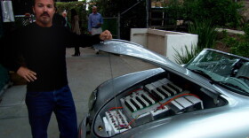 Greg "Gadget" Abbott showing the batteries in his converted car.