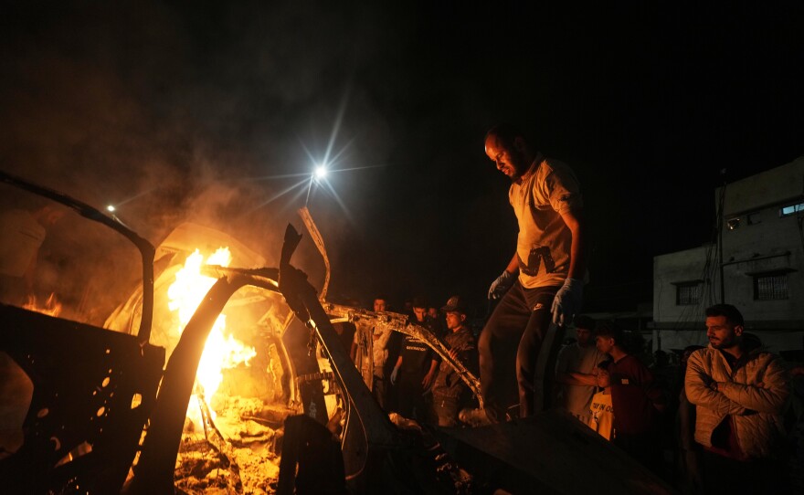 Palestinians gather around a vehicle struck by an Israeli strike in Gaza City, Friday, May 15, 2026.