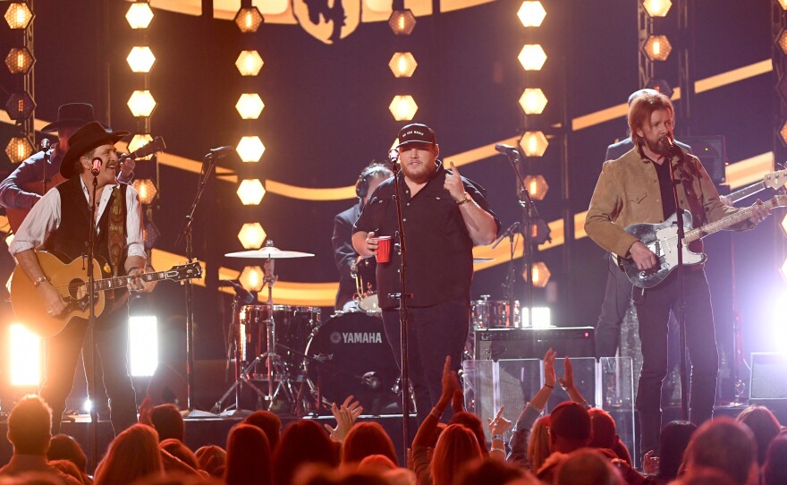 Kix Brooks (left) and Ronnie Dunn (right) of Brooks & Dunn perform with Luke Combs (center) during the Academy Of Country Music Awards in April. Combs appears on Brooks & Dunn's new album, Reboot, which features contemporary country stars collaborating with the duo on a dozen of its classic songs.