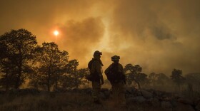 CalFire firefighter Jake Hainey, left, and engineer Anna Mathiasen watch as a wildfire burns near Oroville, Calif., on Saturday, July 8, 2017.