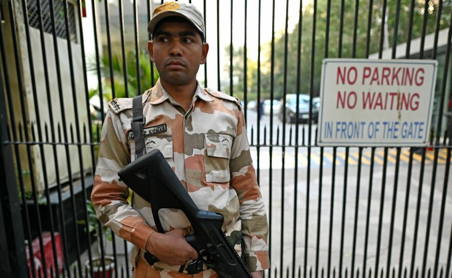 A Border Police officer stands guard outside the office building where Indian tax authorities raided BBC's office in New Delhi.