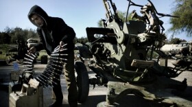 A Libyan civilian holds anti-aircraft ammunition at an army barrack in Benghazi, where dozens of civilians registered for civil defense training amid fears of air raids from Tripoli.