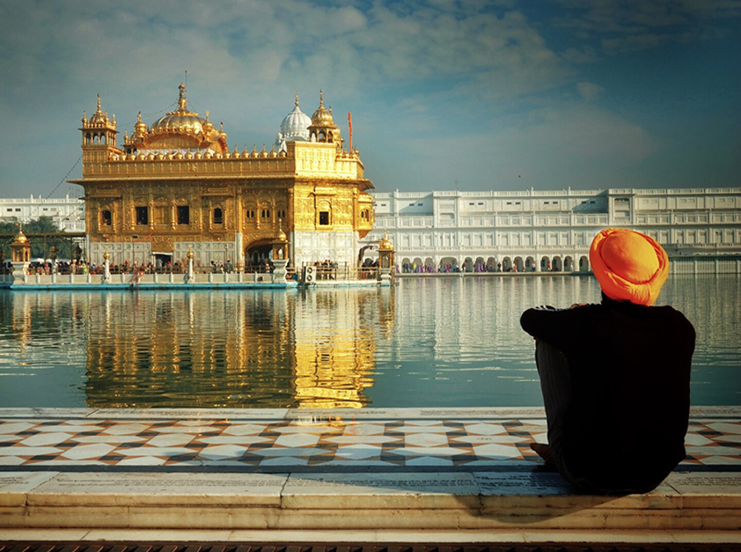 Sikh devotee sitting by the Pool of Nectar, The Golden Temple, Amritsar, India.