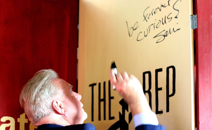 San Diego Repertory Theatre's outgoing artistic director, Sam Woodhouse, is shown in an undated photo writing "be forever curious" on a door.