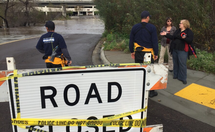 Water from the San Diego River overflows onto a road near Fashion Valley mall, Jan. 7, 2016.