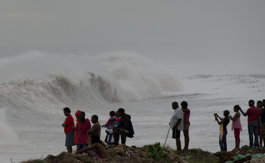 People watch waves break on the outskirts of Kingston, Jamaica, on Monday. Hurricane Matthew has generated large surf, heavy rain and wind.