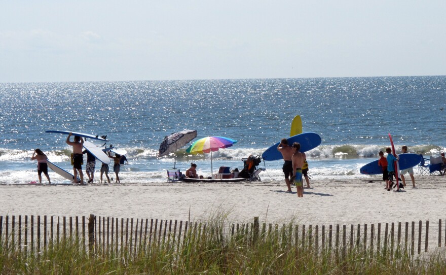Surfers gather on the beach in Ocean City, N.J., in June of last year. A 52-year-old lifeguard who was fired by the city has won a $130,000 age-discrimination suit.