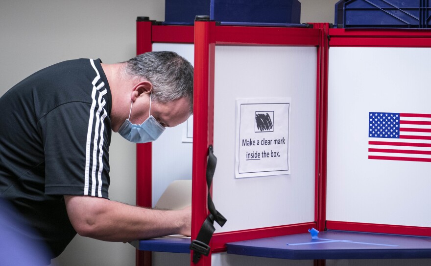 A man casts his ballot for the 2020 presidential election at an early voting location in Alexandria, Virginia.