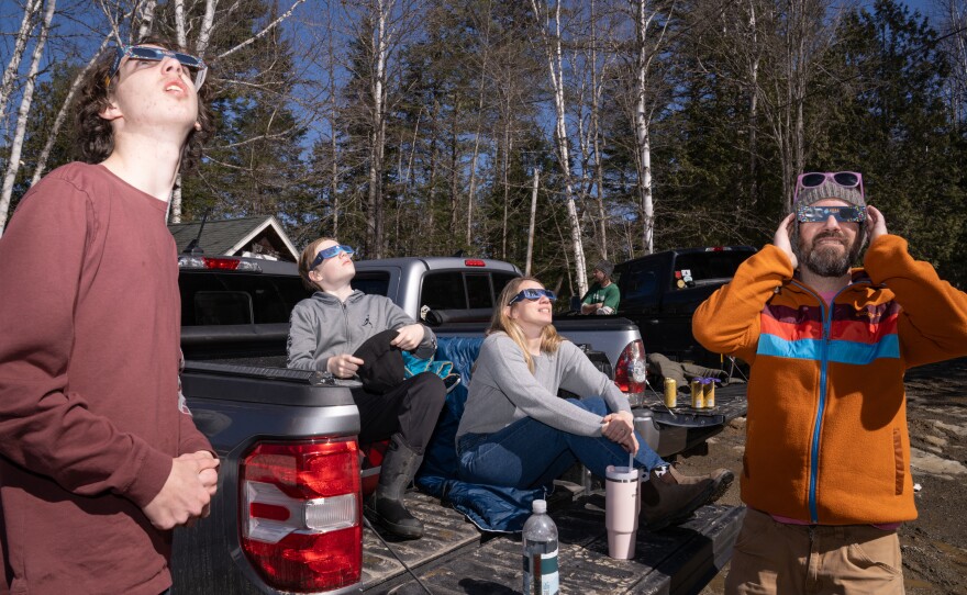 The Carter-Hill family and friends wait for the eclipse in Oquossoc Village in Rangeley, Maine.