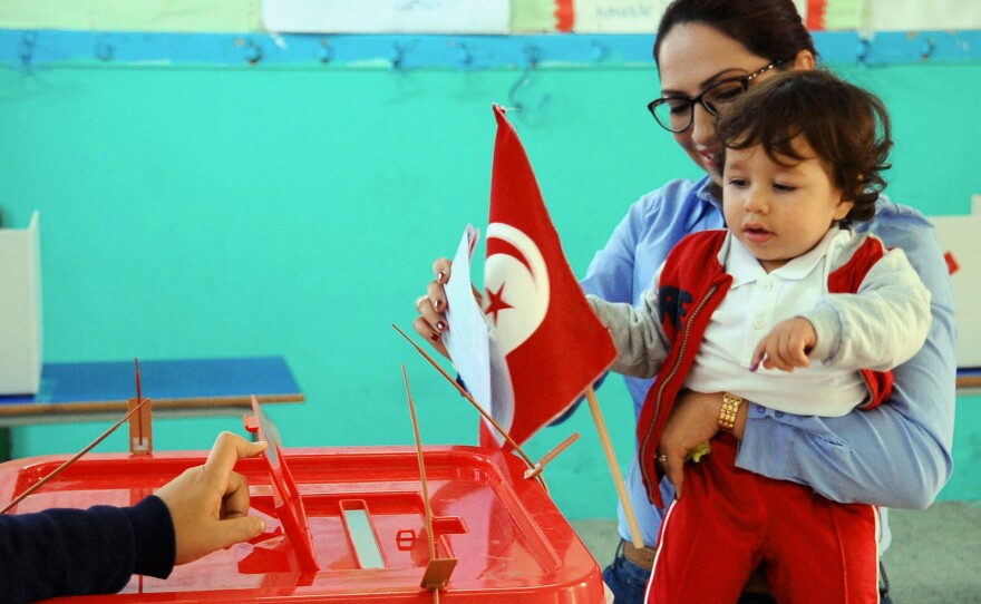 A woman votes in the first round of the Tunisian presidential election on Nov. 23. The election went smoothly, but no candidate won 50 percent of a vote, forcing a run-off between the top two on Sunday.