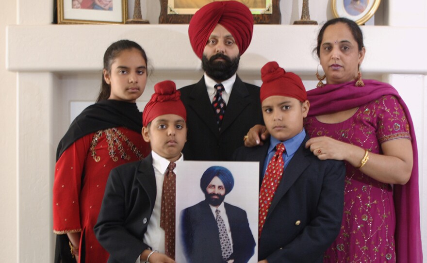 Rana Singh Sodhi (center) with his wife Sukhbir and children who hold a photo of Balbir Singh Sodhi.