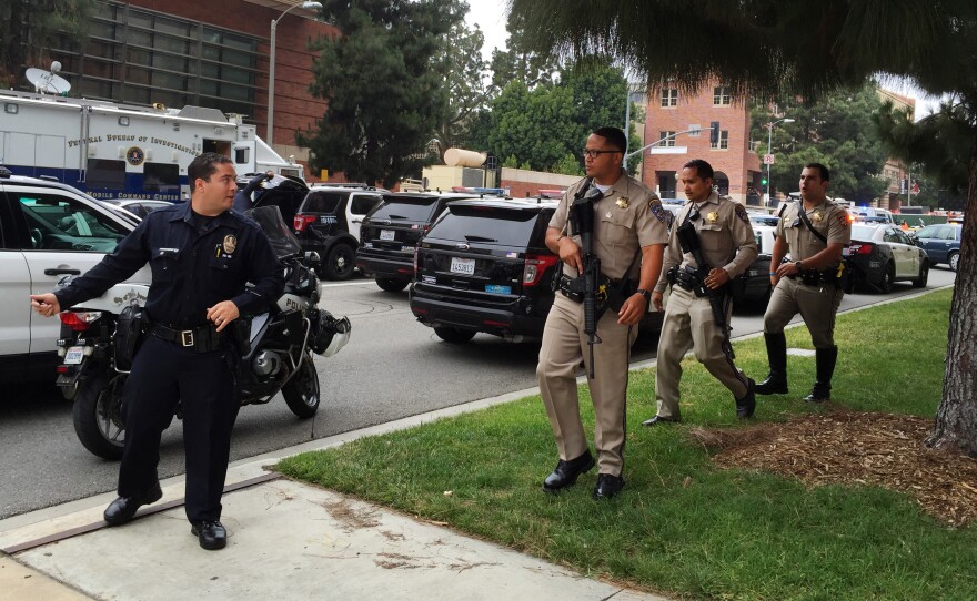 A Los Angeles policeman and sheriff's deputies investigate a fatal shooting at UCLA on Wednesday.