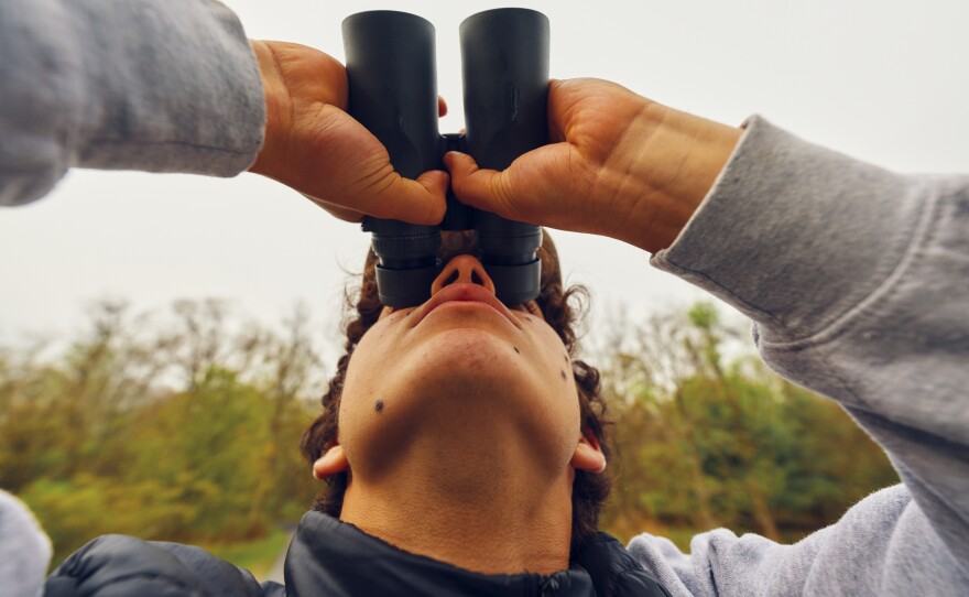 Zade Pacetti, 16, looks through binoculars.
