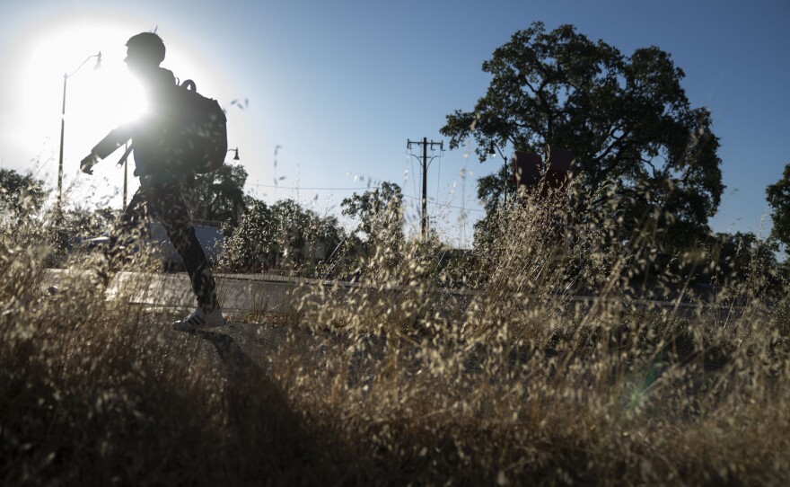 Kevin walks to the school bus stop in California on June 21, 2022. He loves math and hopes to attend college to study architecture or civil engineering, which would make him the first of his family to go to college.