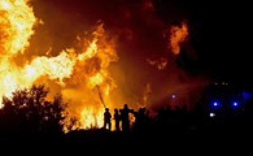 Firefighters try to extinguish a fire in Valparaiso Sunday. The fire, which started in woodland Saturday, has gutted thousands of homes in the historic town.