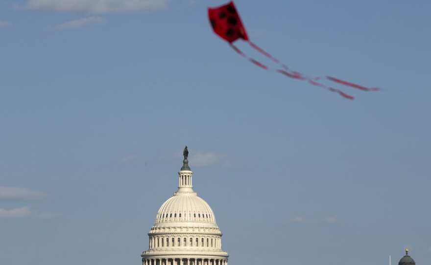 The U.S. Capitol is viewed as a kite flies at the National Mall in Washington earlier this month. Both the House and Senate delayed their return to Washington and leaders are now saying Congress is not expected to return before May 4.