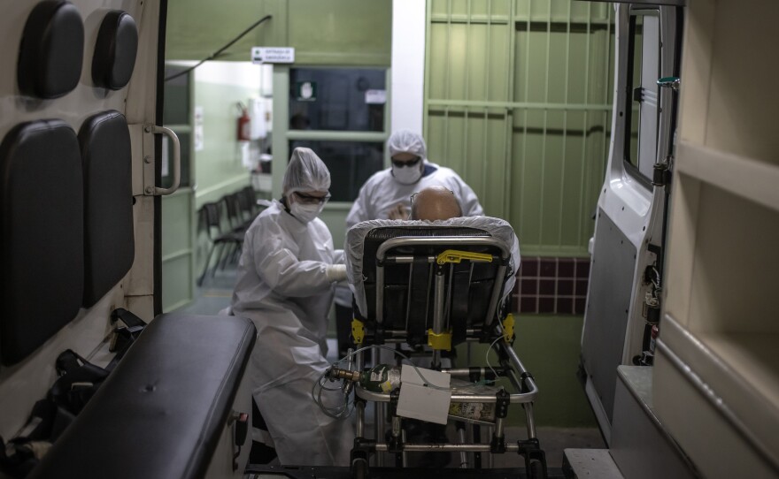 Members of the Mobile Emergency Care Service transfer a patient to a hospital in Sao Paulo state, Brazil, on Feb. 24. ICU beds are full in many hospitals, and now the COVID-19 patients include not just older Brazilians but folks in their 20s and 30s.