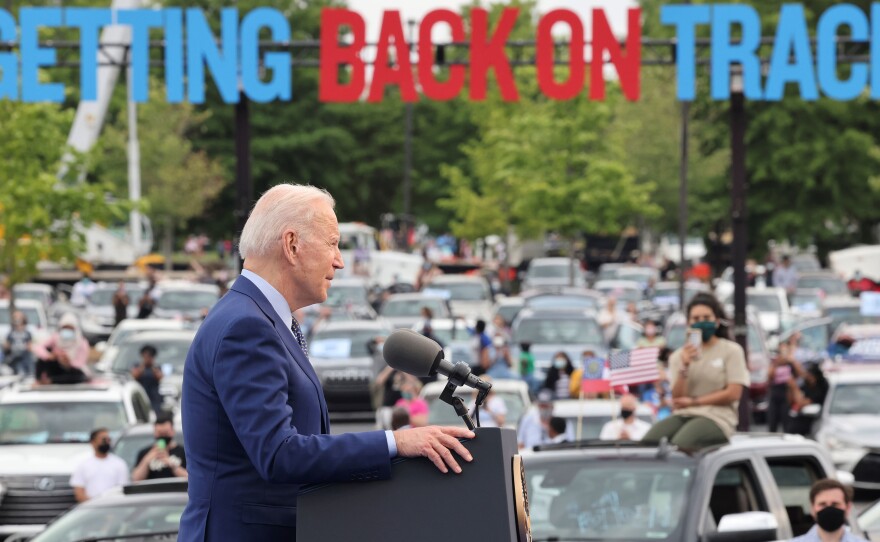 President Joe Biden speaks during the Democratic National Committee's "Back on Track" drive-in car rally in Duluth, Georgia, to celebrate his 100th day in office. Immigrant advocates were there to protest.