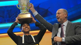 E.W. Scripps Company president and CEO Adam Symson holds the trophy over Shrey Parikh, winner of the 2026 Scripps National Spelling Bee, at DAR Constitution Hall in Washington, D.C. on Thursday.