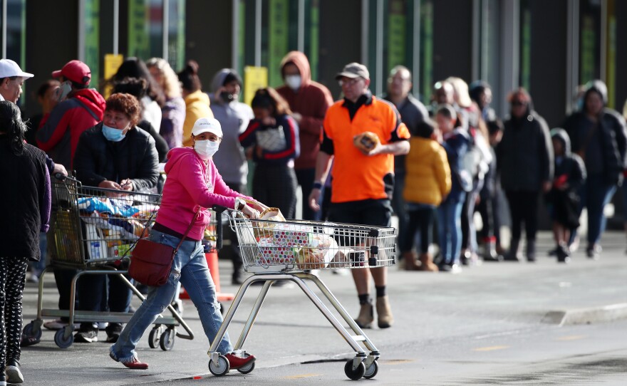 People queued outside a supermarket in Auckland, New Zealand, on Wednesday before a three-day lockdown went into affect. Four new COVID-19 cases were diagnosed in Auckland, and an additional four probable cases have been identified.