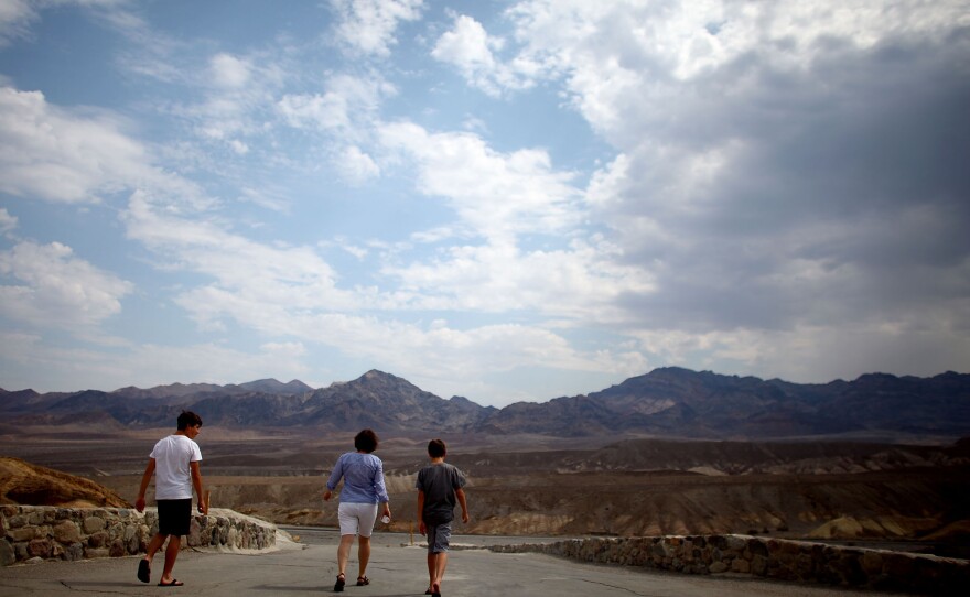 A family walks away from Zabriskie Point.