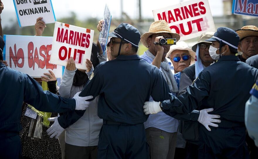 Police officers block the road as people stage a rally against the U.S. military presence on Okinawa.