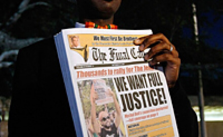 A man holds a newspaper with a front-page story about the Jena Six before the start of a civil rights march in Jena, La., Thursday.