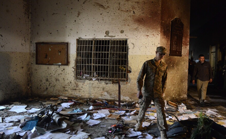 A Pakistani soldier walks amidst the debris in an army-run school a day after an attack by Taliban militants in Peshawar on Wednesday.