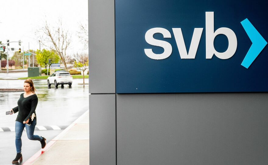 A property manager representative passes a sign at Silicon Valley Banks headquarters in Santa Clara, California on March 10, 2023.
