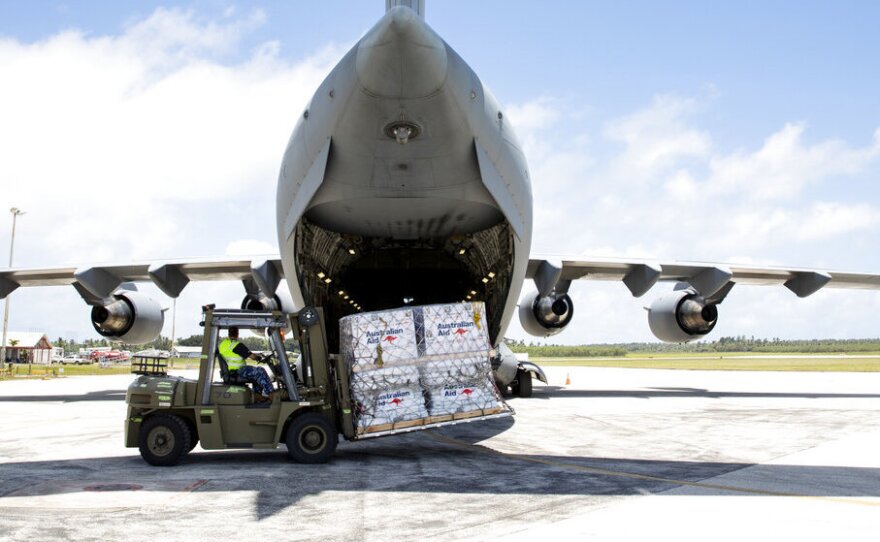 In this photo provided by the Australian Defence Force, personnel unload emergency aid supplies at Tonga's Fuaʻamotu International Airport, near Nukuʻalofa, Thursday, Jan. 20, 2022, after a volcano eruption.