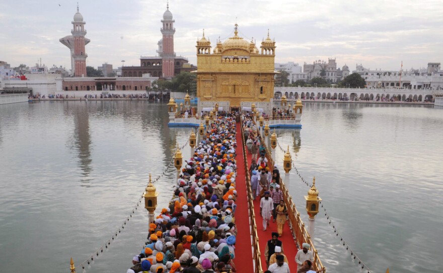 Sikh pilgrims stream into the Golden Temple in Amritsar, India, on Nov. 10. Devout Sikhs from all over India and the world come to Amritsar by the tens of thousands every day â adding to an already sizable carbon footprint. So city and temple officials have joined an environmental group to learn how to incorporate environmentally friendly practices.