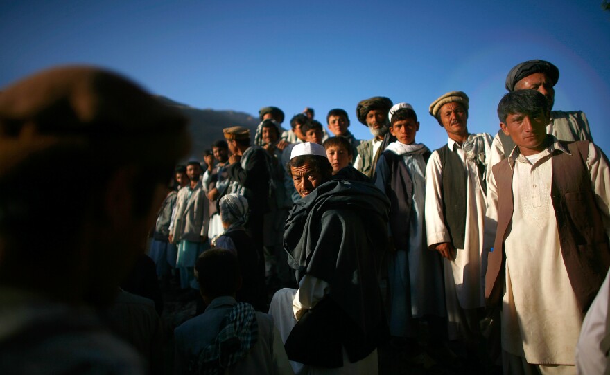 Afghan men assemble for a campaign visit from President Hamid Karzai.