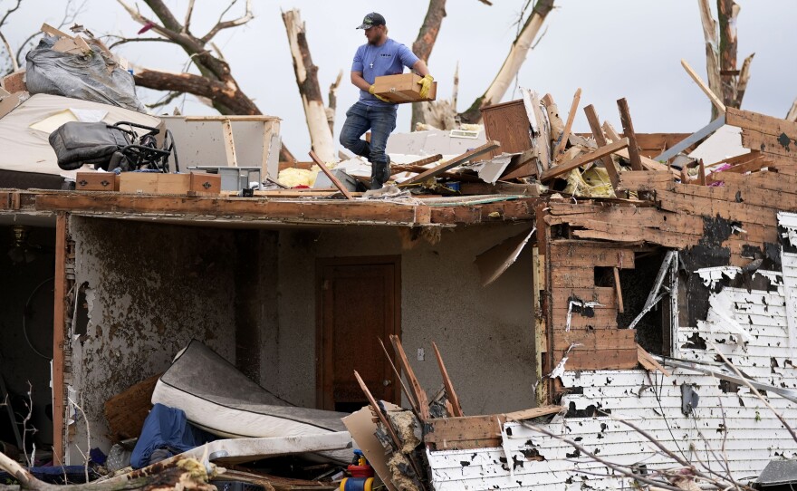 A man sorts through the remains of a home damaged by a tornado on Tuesday in Greenfield, Iowa.