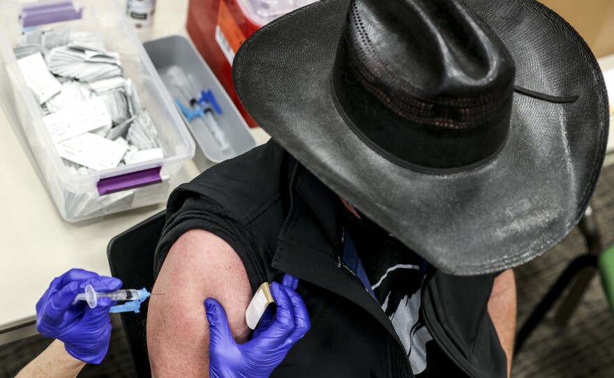 Colorado's UCHealth hospital system is requiring any prospective organ transplant recipients to get the COVID-19 vaccine. Here, a man receives a COVID-19 vaccine in Thornton, Colo., earlier this year.