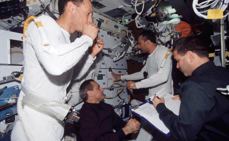 Astronauts James H. Newman (left) and Michael J. Massimino wear the liquid cooling and ventilation garment that complements the spacesuit during a 2002 mission. Also pictured on the Columbia space shuttle are pictured are astronauts John M. Grunsfeld (right) and Richard M. Linnehan.