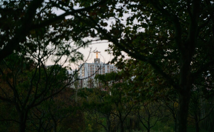 Trees in Parque da Paz frame the Cristo Rei statue in Lisbon.