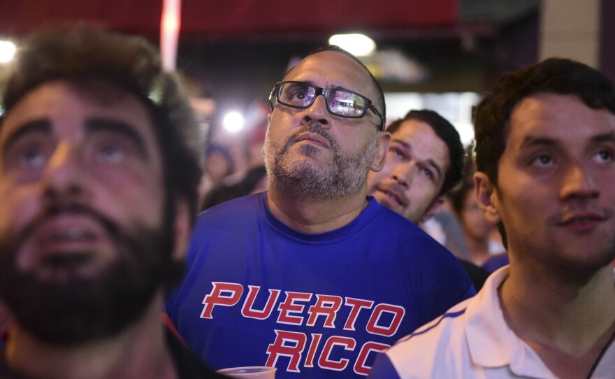 Fans gather Wednesday in the street in San Juan, Puerto Rico, to watch the World Baseball Classic final match between Puerto Rico and the United States. Puerto Rico's team reached the final game of the tournament undefeated.