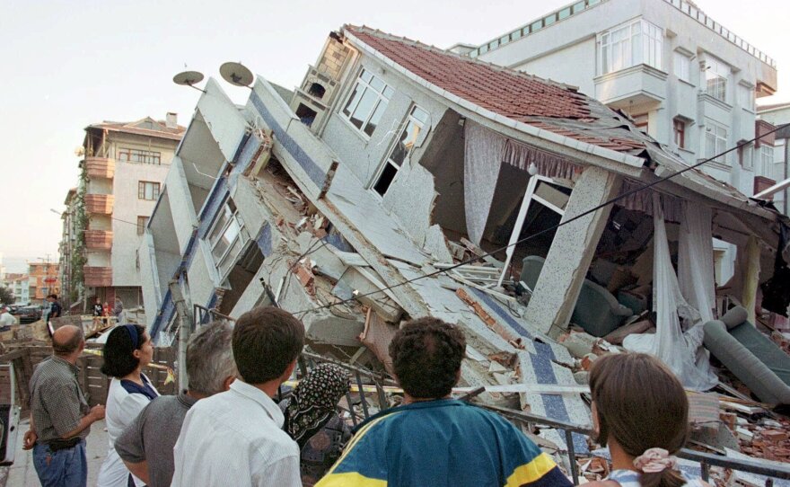 Earthquake survivors look at a collapsed building in Istanbul in August 1999. The magnitude 7.4 quake killed 17,000 people across northwestern Turkey.
