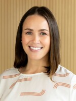 Woman smiling at camera with white shirt and dark hair.