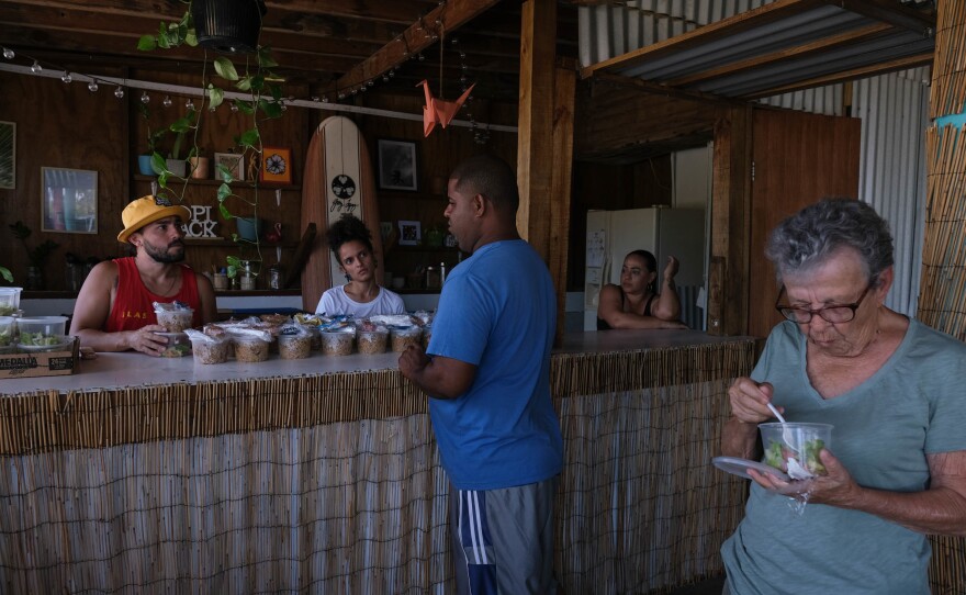 Residents of the Pozuelo community in Guayama, Puerto Rico, pick up meals at the Tropishack.