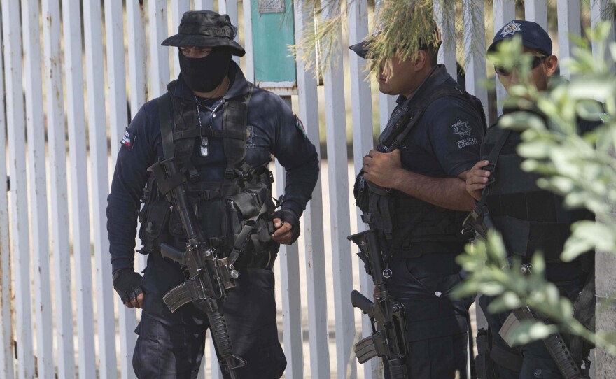 Mexican state police stand guard in May 2015 near a shootout between authorities and suspected criminals in Michoacan. Mexico's National Human Rights Commission said Thursday that 22 people were arbitrarily killed by federal police during that raid.