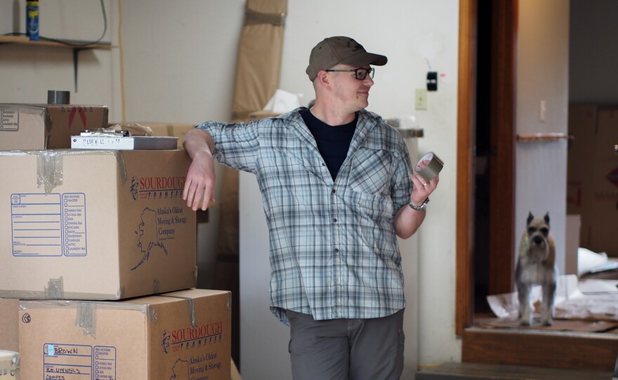 Lt. Col. Alan Brown stands in his garage, filled with boxes that will be sent to the family's new home in New York. In the background is Lucy, the family's Schnauzer.