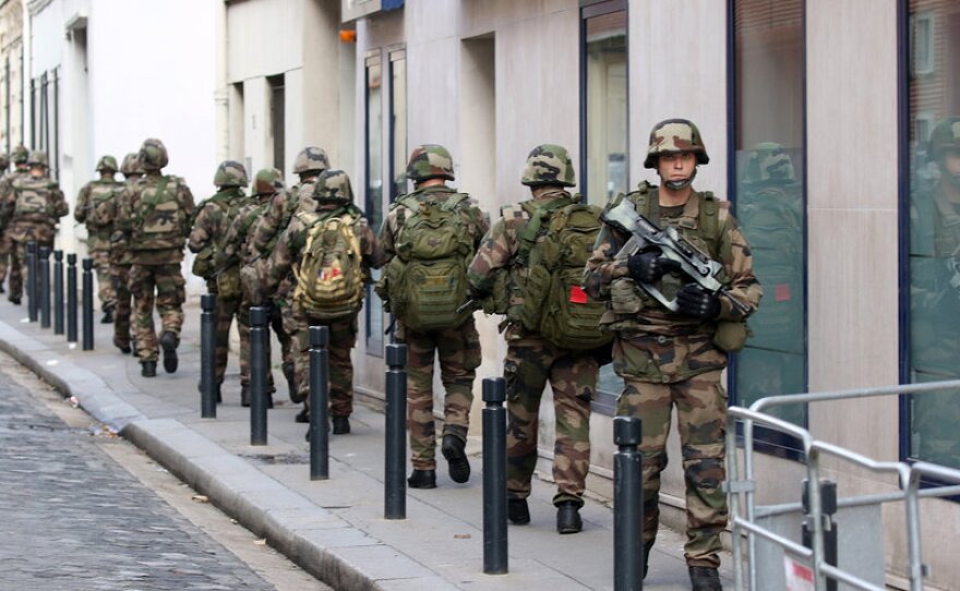 Soldiers patrol a street of Saint-Denis, a suburb of Paris, on Wednesday. Special forces raided an apartment, hunting those behind the attacks that claimed 129 lives in the French capital on Friday.