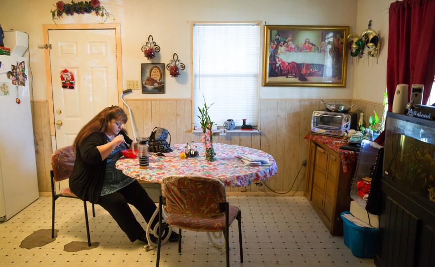 Garcia eats her dinner before attending church on a Wednesday evening. Garcia, who works two jobs, rents a room in her brother's home to save on expenses.