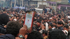 An Afghan demonstrator holds a half-burnt copy of the Koran, allegedly set on fire by U.S. soldiers, at the gate of Bagram airbase during a protest against Koran desecration at Bagram, about 60 kilometres (40 miles) north of Kabul, on February 21, 2012.