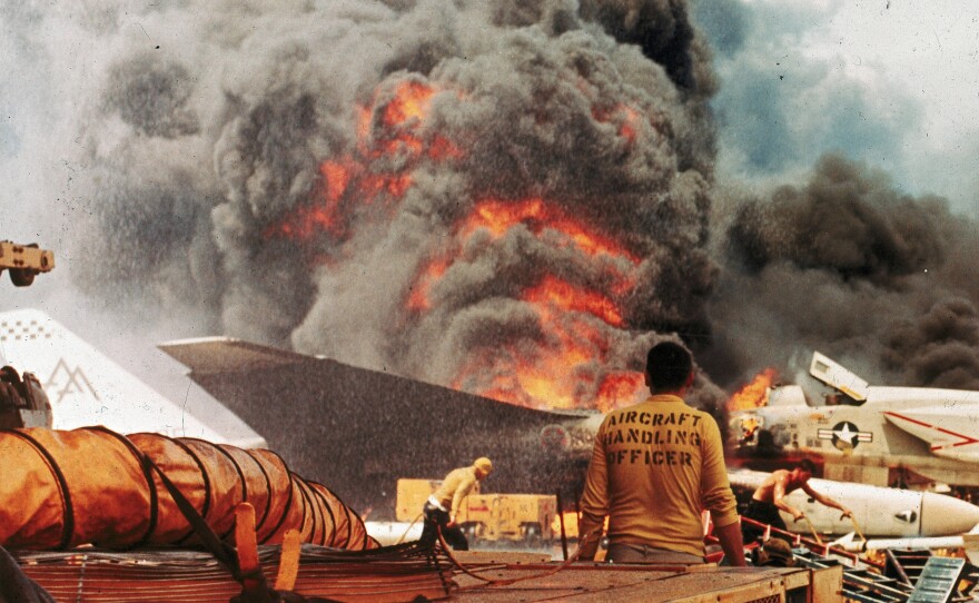 Navy crewmen try to put out a fire aboard the USS Forrestal in the Tonkin Gulf, off the coast of Vietnam, on July 29, 1967.