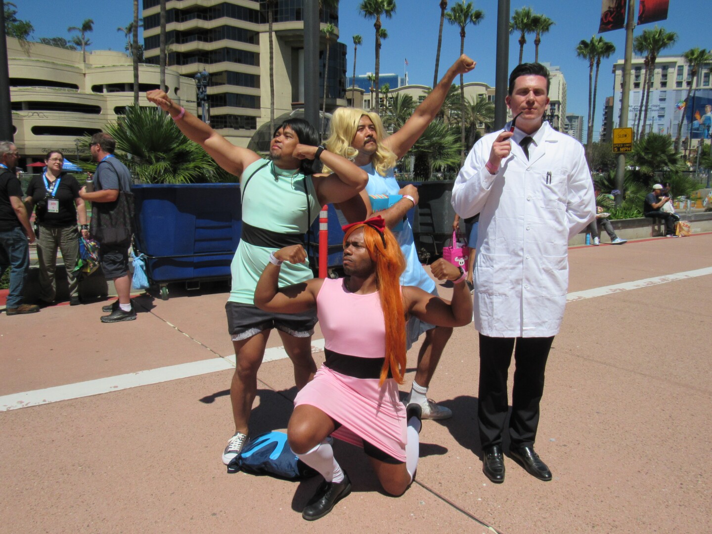 Comic-Con attendees dressed as the Power Puff Girls and Professor X strike a pose in front of the San Diego Convention Center on July 26, 2025.