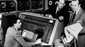 Walter Cronkite (right) listens as Dr. J. Presper Eckert (center) describes the functions of the UNIVAC I computer he helped develop in the early 1950s.